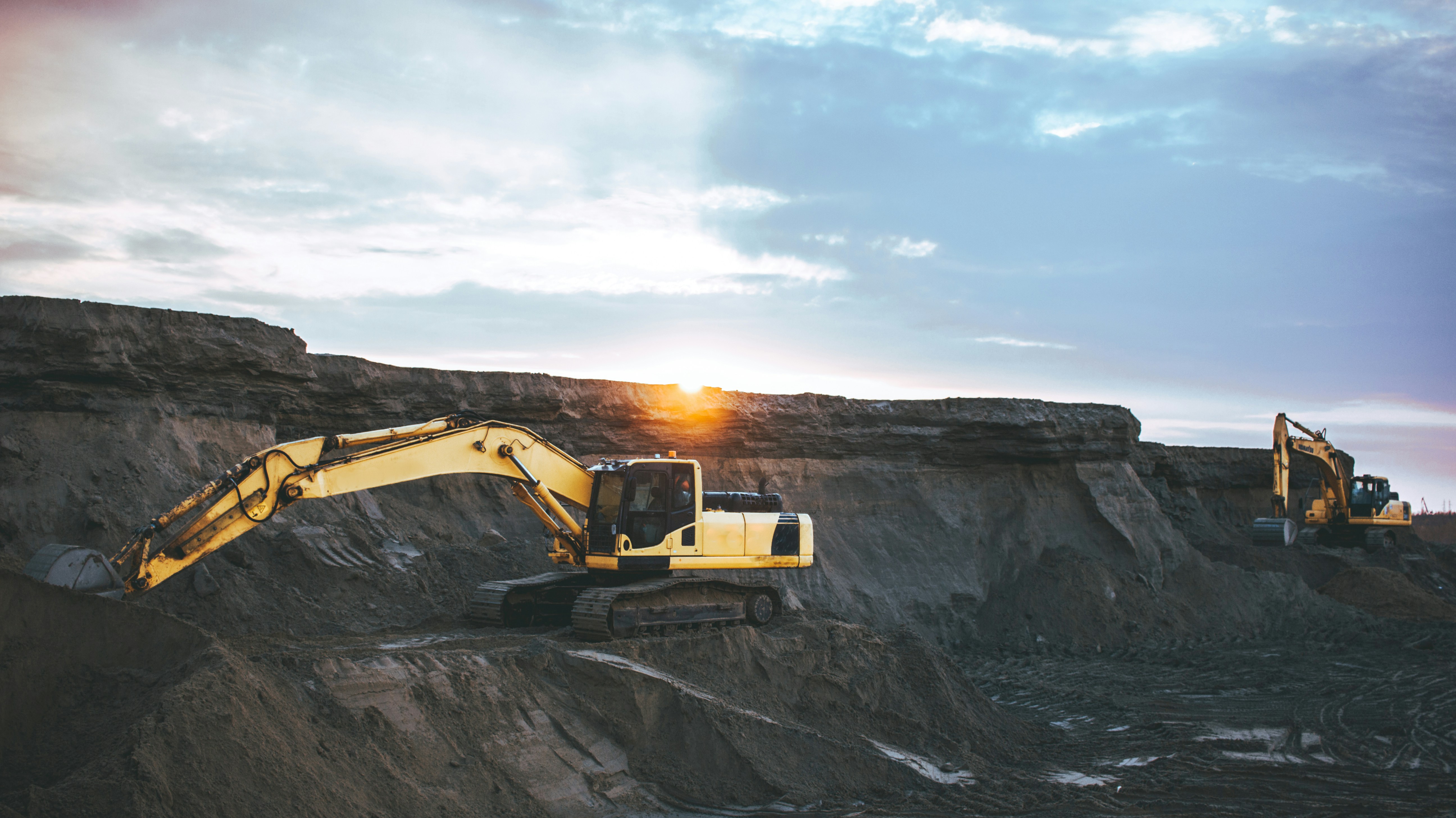 Open-pit mining excavators at golden hour